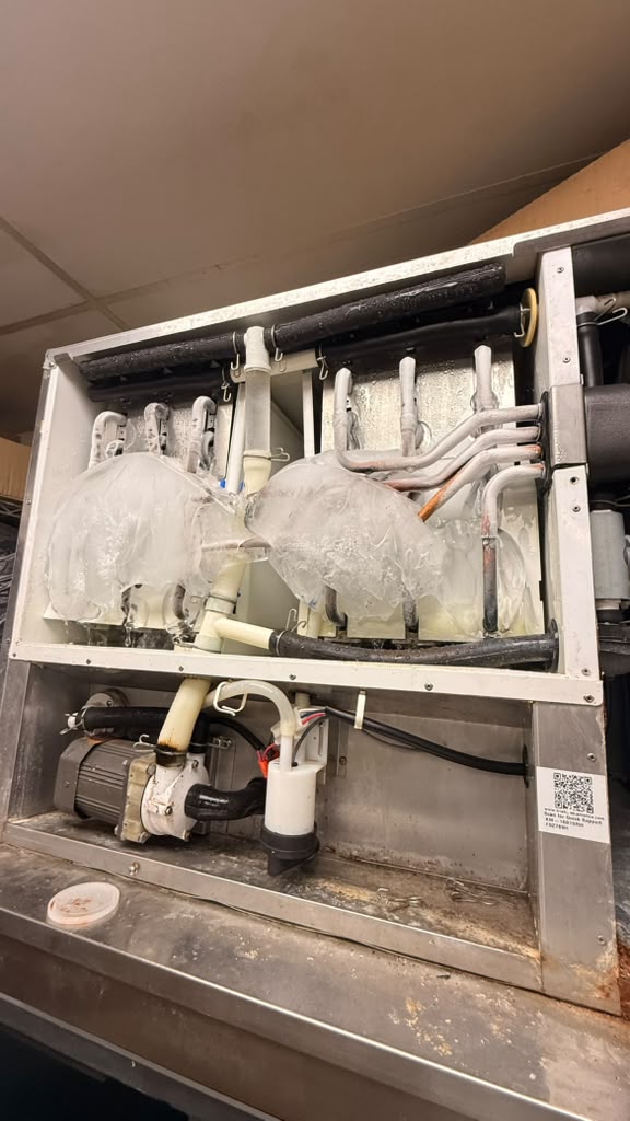 Heavy ice buildup on the coils and lines inside a commercial refrigeration unit